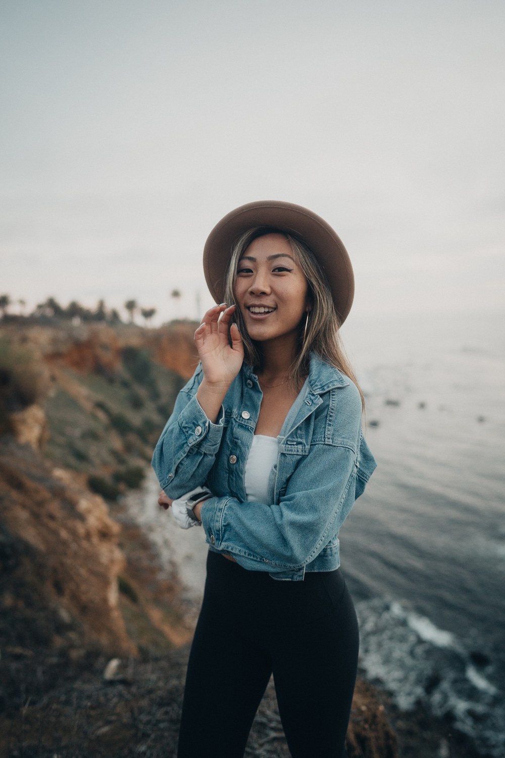 Grace Kim wearing a hat and denim jacket on the Los Angeles coast