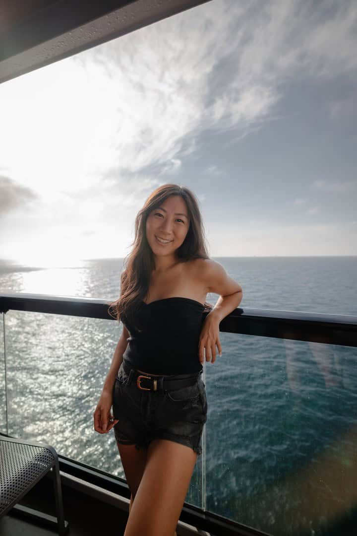Grace Kim on a Virgin Voyages cruise balcony overlooking the ocean