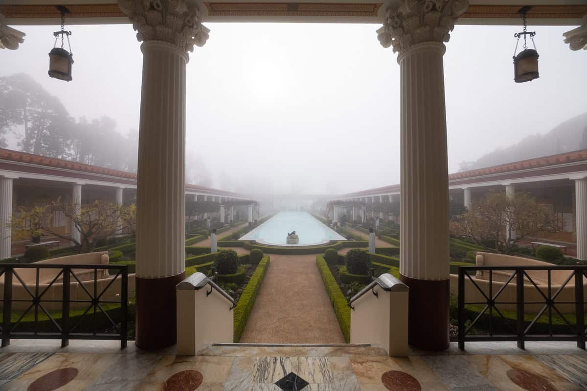 Getty Villa garden and reflecting pool seen between stone columns