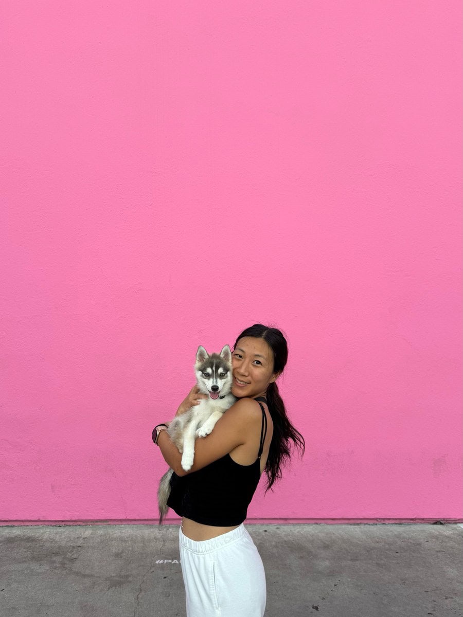 Grace holding Rocket in front of the Paul Smith Pink Wall
