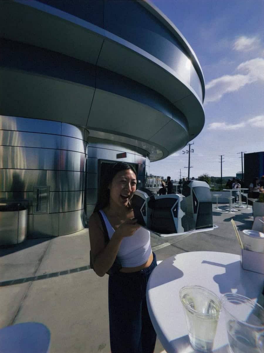 Grace beside the curved exterior of Tesla Diner