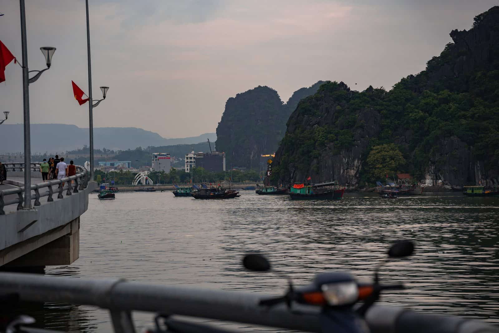 Boats near the pier and limestone karsts on Ha Long Bay, Vietnam