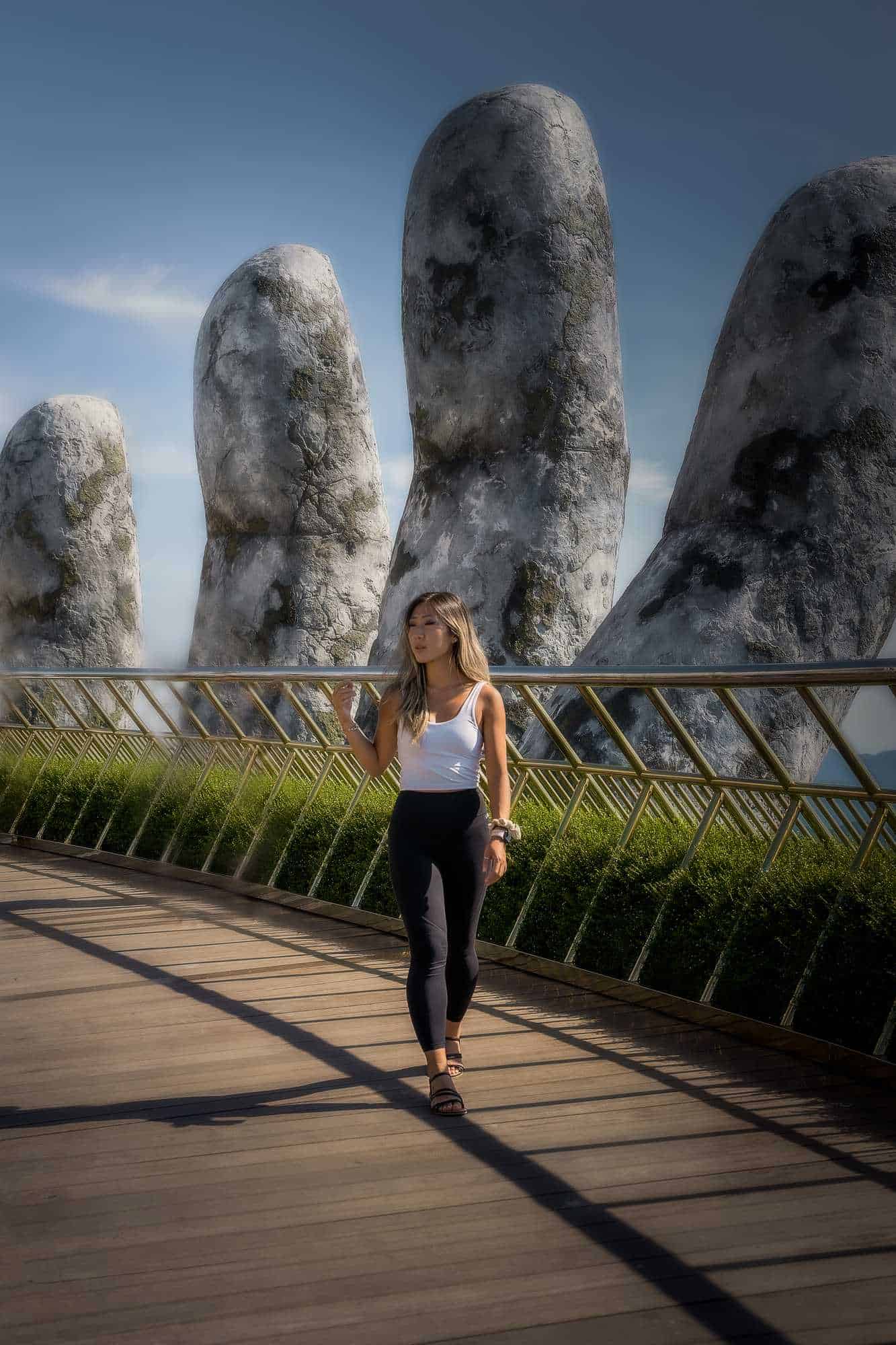 Grace standing on the Golden Bridge beside the giant stone hand at Ba Na Hills, Vietnam