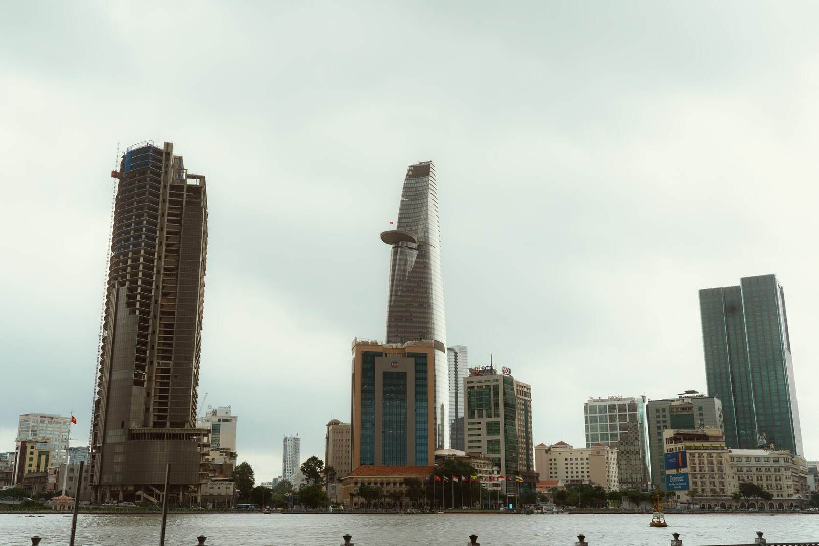 Ho Chi Minh City riverfront skyline with Bitexco Financial Tower beneath an overcast sky