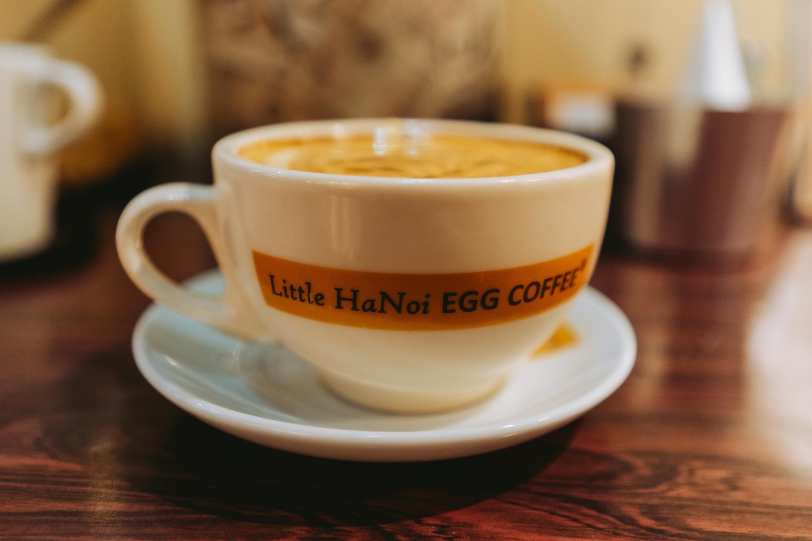 Cup of egg coffee on a saucer at Little Hanoi Egg Coffee in Saigon