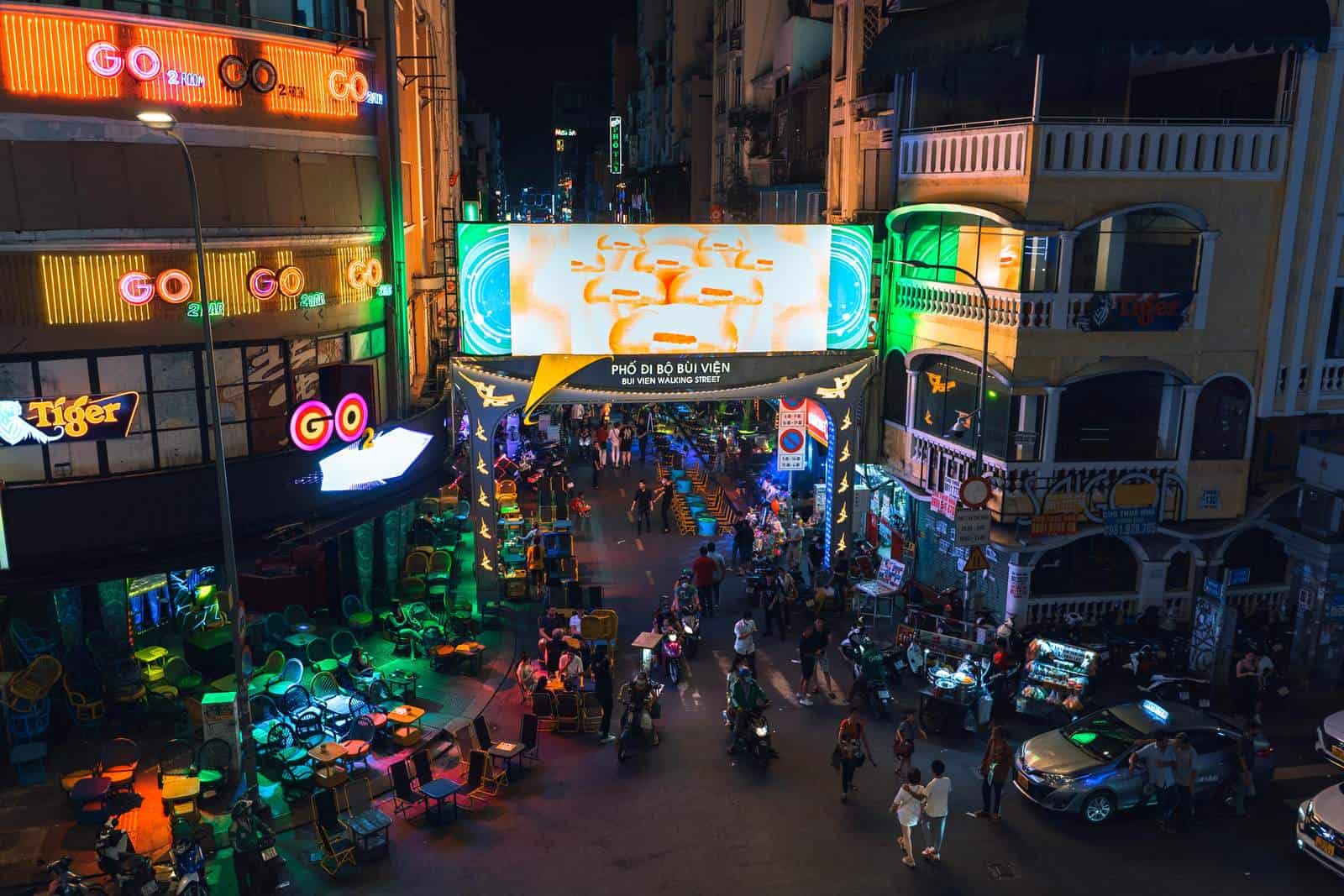 Neon signs, pedestrians and motorbikes on Bui Vien Walking Street at night