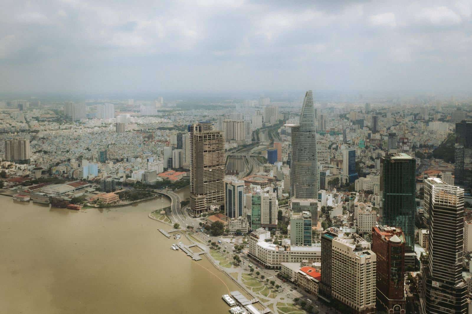 Aerial view of central Ho Chi Minh City and the Saigon River beneath cloudy skies