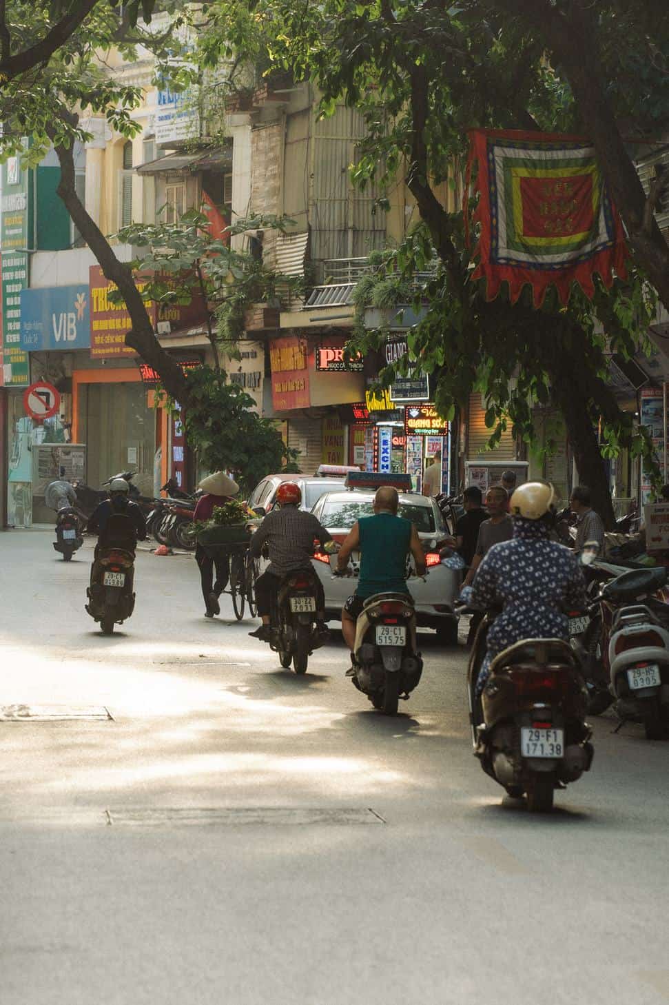 Motorbikes and storefronts along a busy street in Hanoi