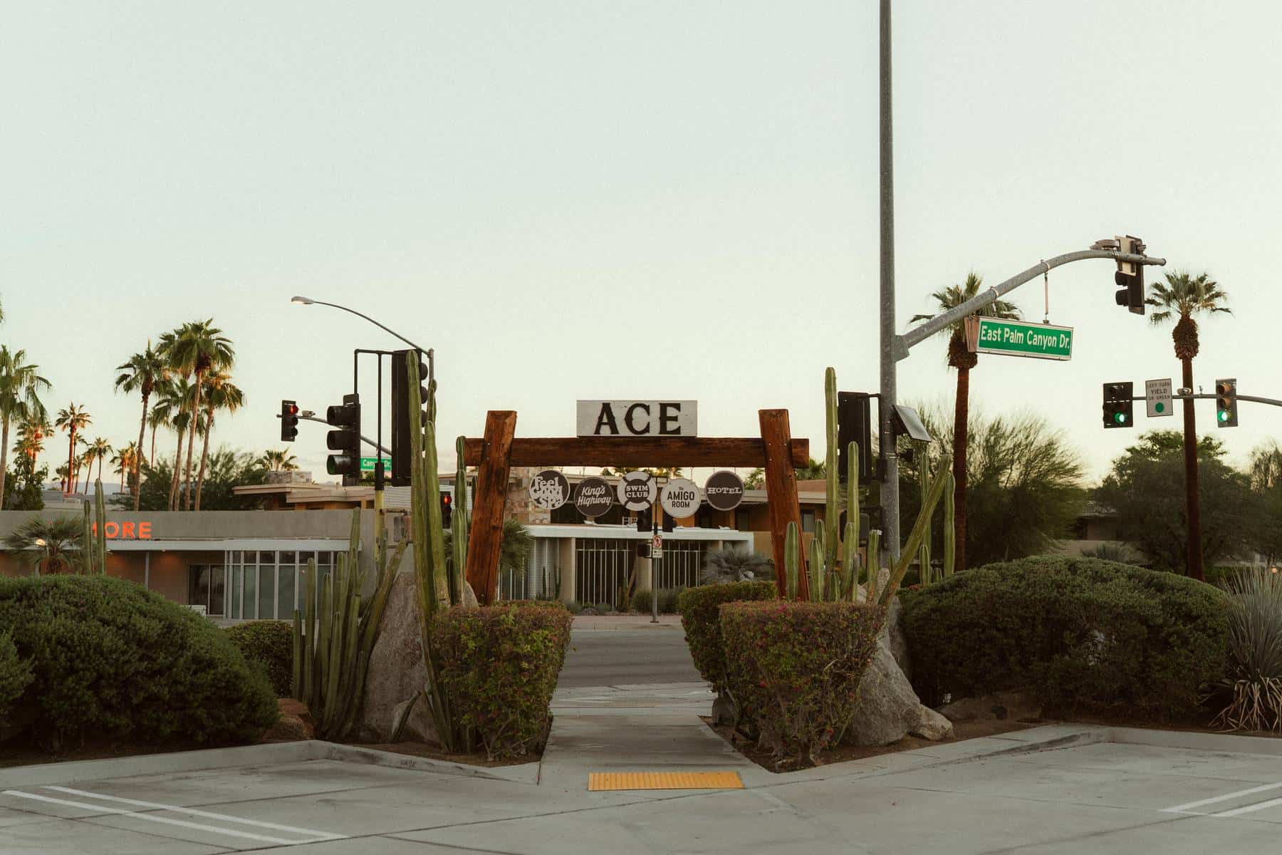 The Ace Hotel Palm Springs entrance sign on East Palm Canyon Drive, with signs for King's Highway, the Swim Club and the Amigo Room